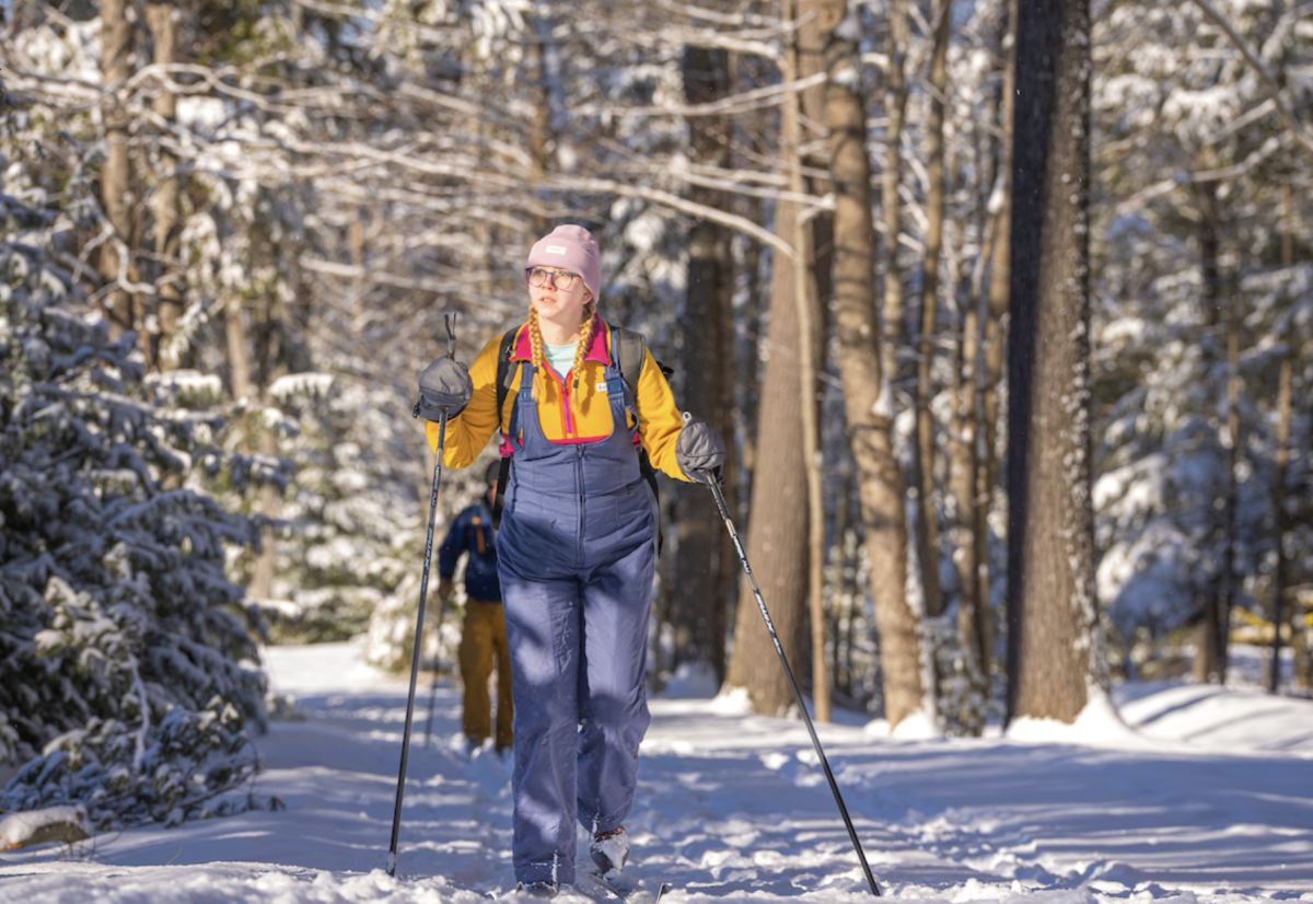 University of Maine - student cross country skiing in the woods